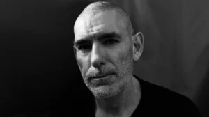 Black and white close up portrait of a middle-aged man with a shaved head and short beard, illustrating focus and professionalism for a Brisbane self-tape studio.